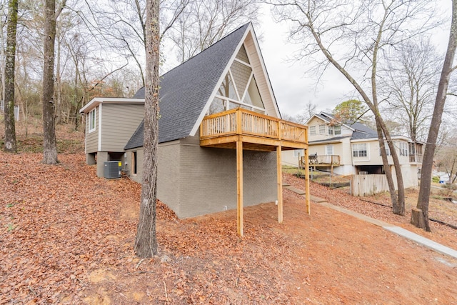 view of side of home featuring cooling unit and a wooden deck