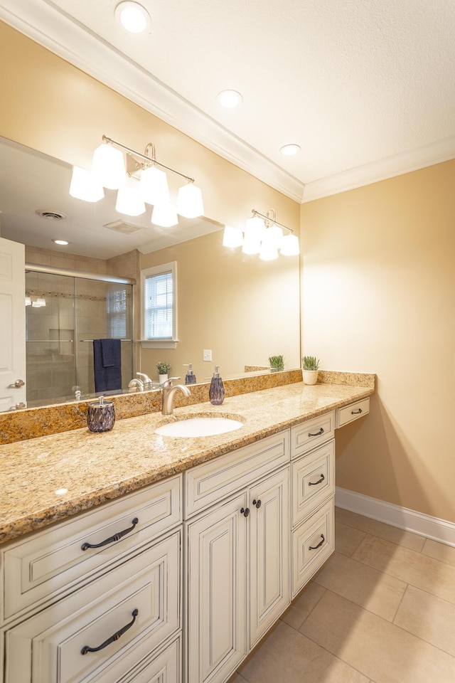 bathroom featuring vanity, tile patterned flooring, crown molding, and walk in shower