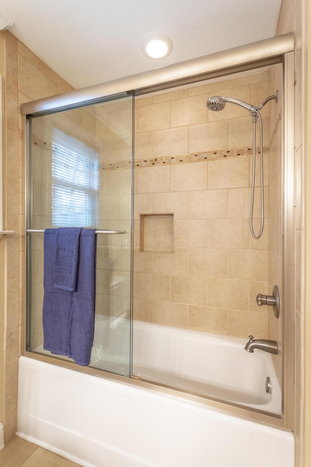 bathroom featuring bath / shower combo with glass door