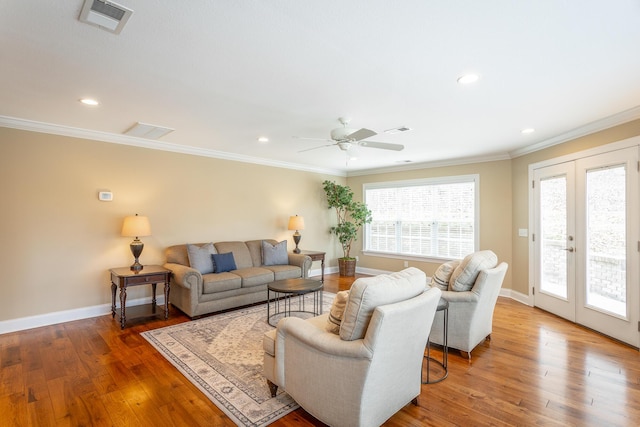 living room with french doors, crown molding, and hardwood / wood-style flooring