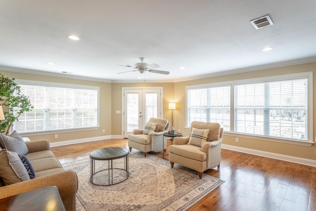 living room featuring french doors, plenty of natural light, crown molding, and hardwood / wood-style floors