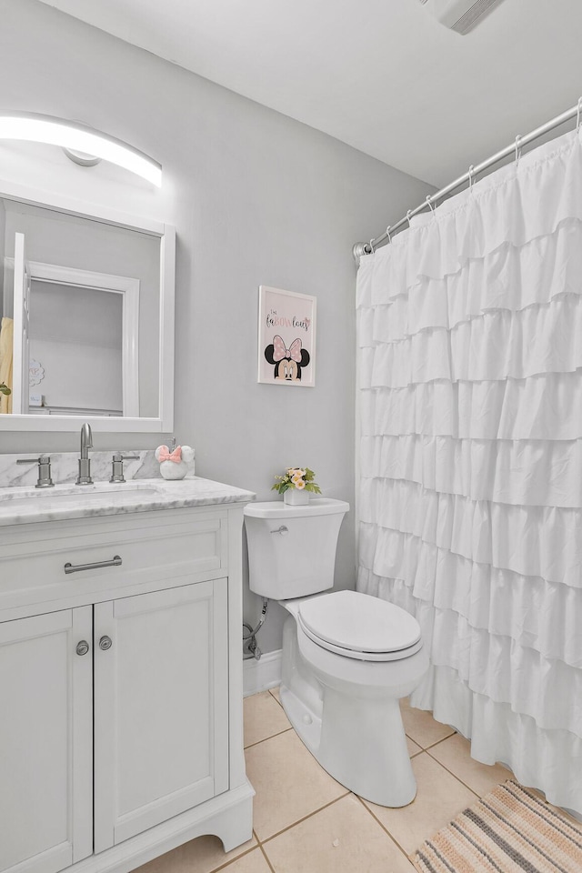 bathroom featuring tile patterned flooring, vanity, curtained shower, and toilet