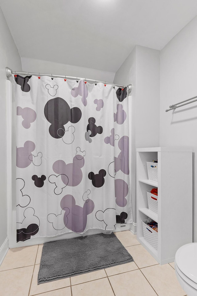 bathroom featuring tile patterned floors, toilet, and shower / tub combo