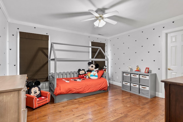 bedroom with crown molding, hardwood / wood-style flooring, and ceiling fan