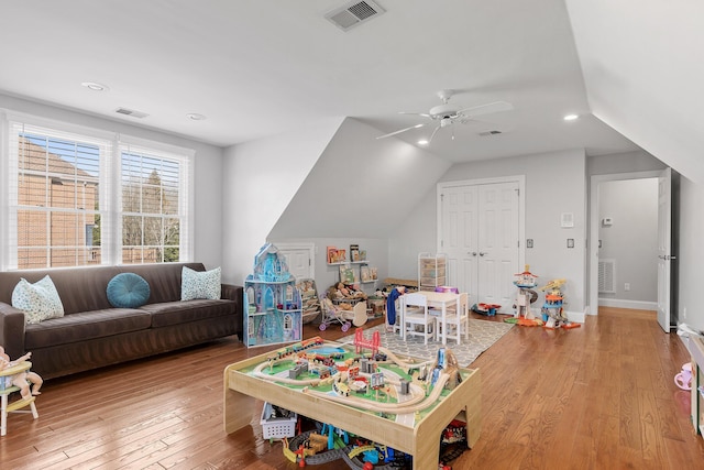 game room with lofted ceiling, light hardwood / wood-style floors, and ceiling fan