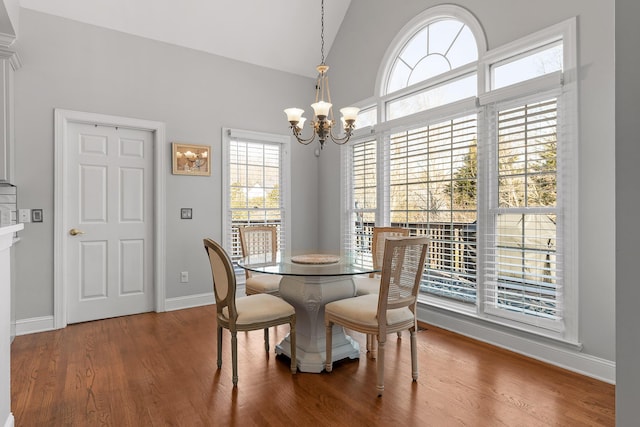 dining room with lofted ceiling, a notable chandelier, and wood-type flooring