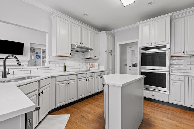 kitchen with sink, ornamental molding, stainless steel double oven, black electric stovetop, and white cabinets