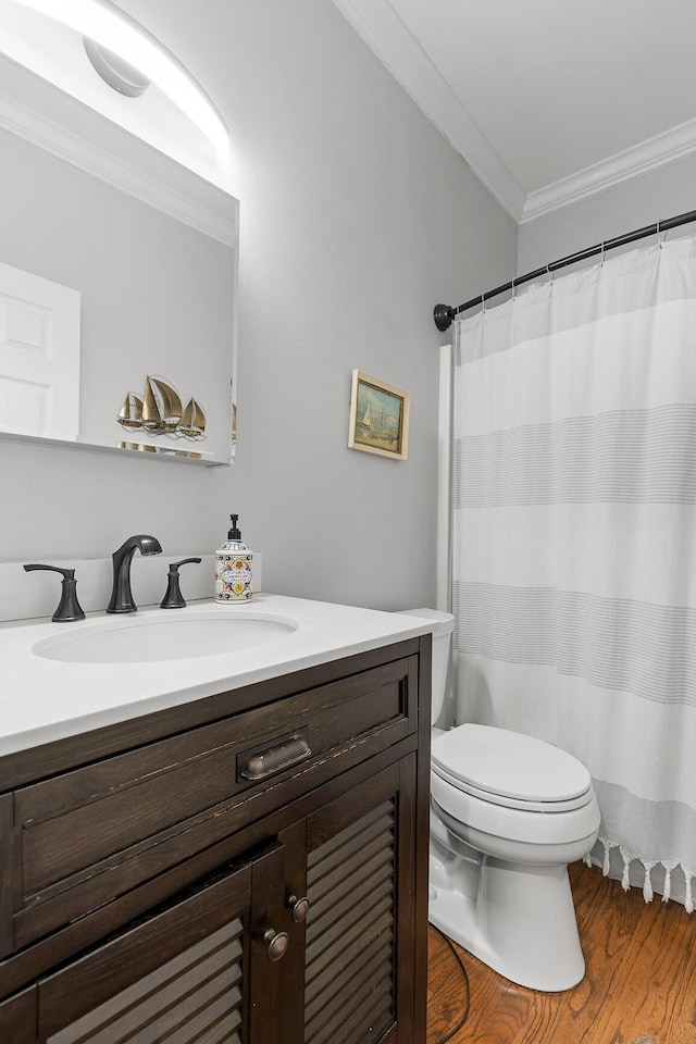 bathroom featuring vanity, hardwood / wood-style flooring, ornamental molding, and toilet