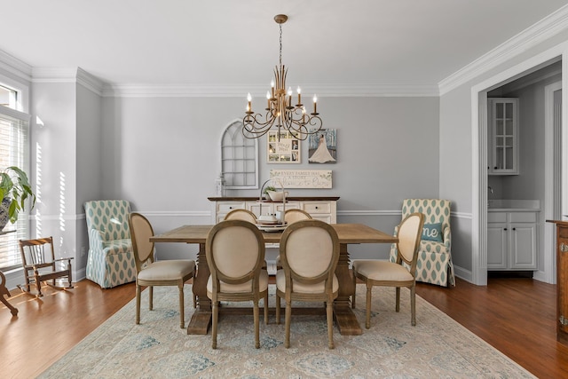 dining area featuring crown molding, dark hardwood / wood-style flooring, and a chandelier