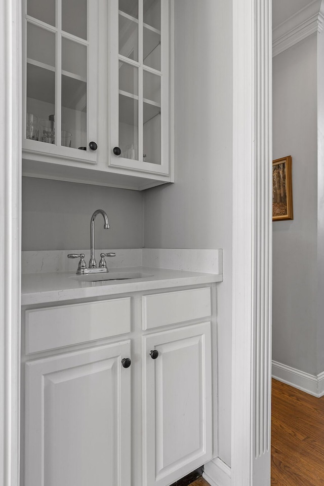 bar with white cabinetry, dark wood-type flooring, sink, and crown molding