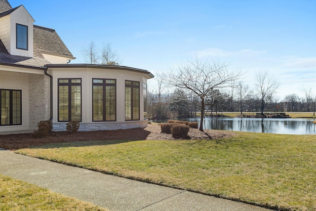 view of yard with a water view and a sunroom