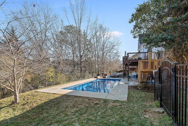 view of pool with a wooden deck, a yard, and a patio area