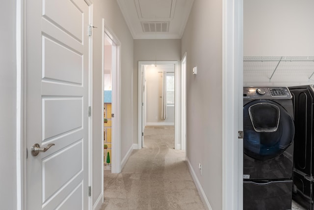 corridor featuring light colored carpet and washer and dryer