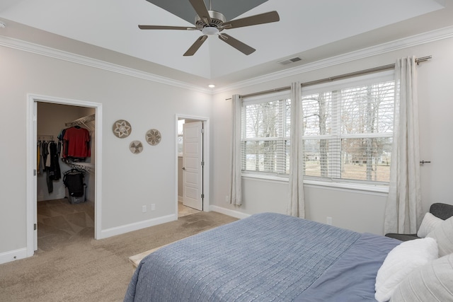 bedroom featuring crown molding, a walk in closet, light colored carpet, and a closet