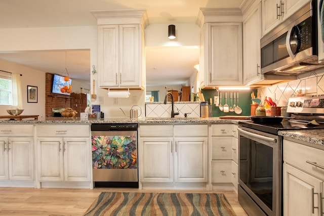 kitchen featuring light stone counters, stainless steel appliances, and sink