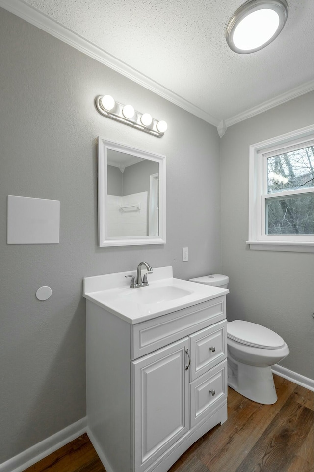 bathroom with vanity, hardwood / wood-style floors, crown molding, and toilet