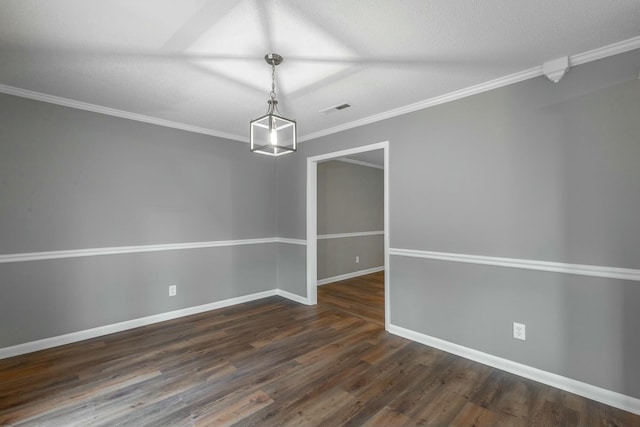 spare room featuring dark wood-type flooring, crown molding, and a textured ceiling