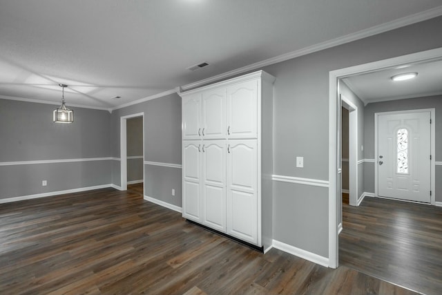 interior space with ornamental molding and dark wood-type flooring