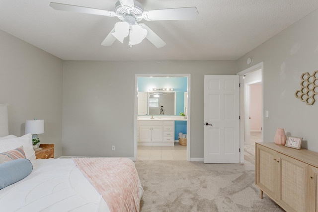 bedroom with light carpet, connected bathroom, a textured ceiling, and ceiling fan