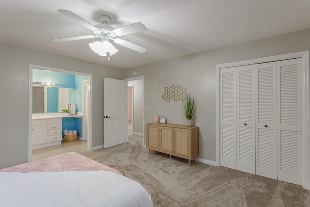 bedroom with ceiling fan, a closet, ensuite bathroom, and light carpet