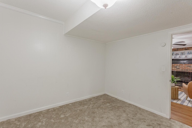 empty room with crown molding, carpet floors, and a textured ceiling