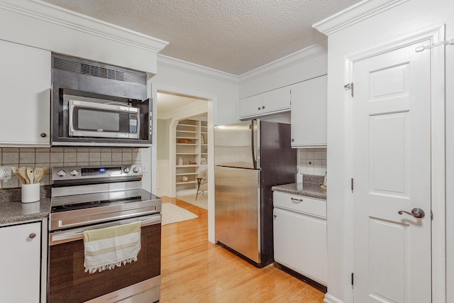 kitchen featuring appliances with stainless steel finishes, white cabinetry, crown molding, a textured ceiling, and light wood-type flooring