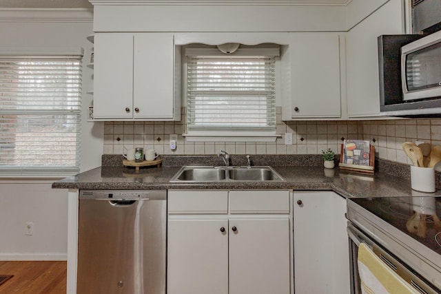 kitchen featuring stainless steel appliances, a healthy amount of sunlight, sink, and white cabinets