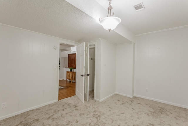 bonus room featuring light colored carpet and a textured ceiling