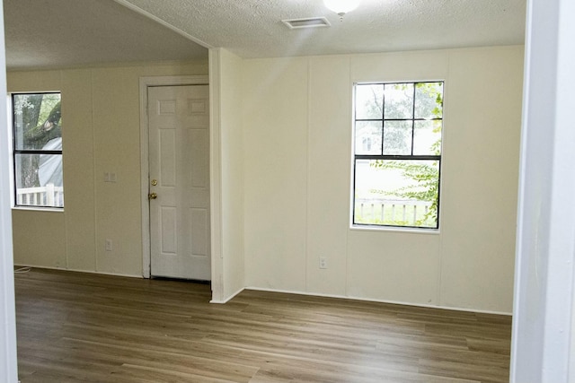 spare room featuring hardwood / wood-style flooring and a textured ceiling