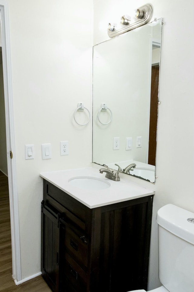 bathroom with hardwood / wood-style flooring, vanity, and toilet