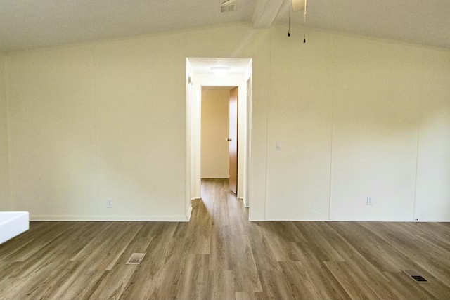 unfurnished room featuring hardwood / wood-style flooring and lofted ceiling with beams