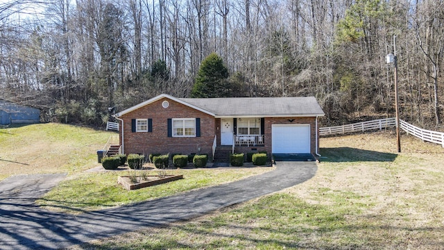 single story home with a garage, a porch, and a front lawn