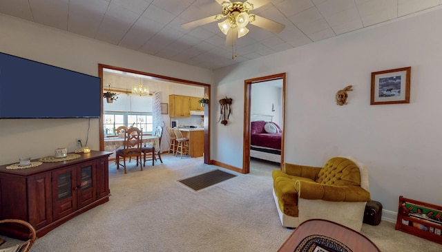 living room with ceiling fan with notable chandelier and light carpet