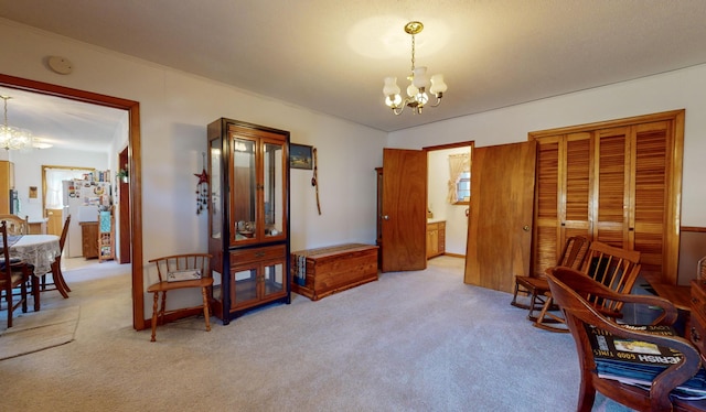 living area featuring an inviting chandelier and carpet flooring