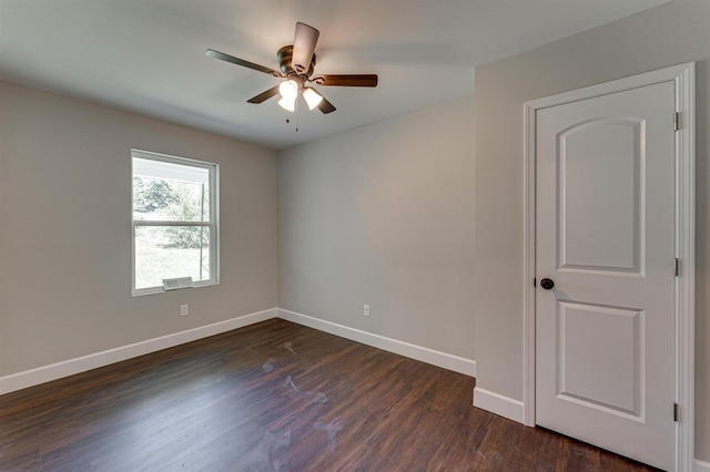 empty room featuring dark wood-type flooring and ceiling fan