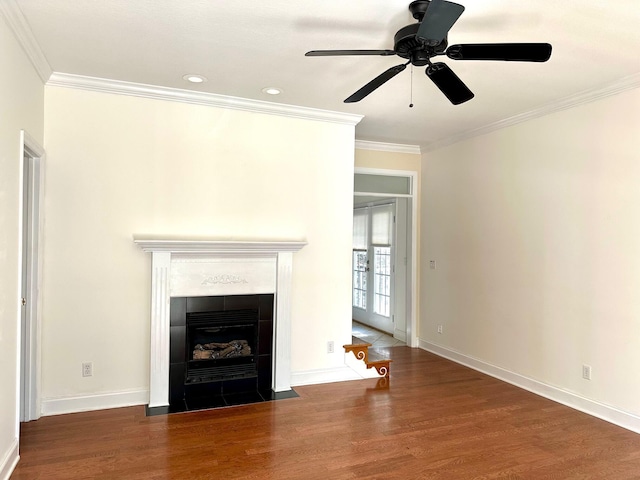 unfurnished living room with ornamental molding, a tile fireplace, and dark hardwood / wood-style floors