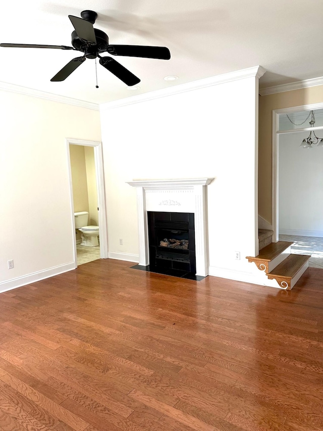 unfurnished living room featuring a tile fireplace, dark hardwood / wood-style floors, ceiling fan, and crown molding