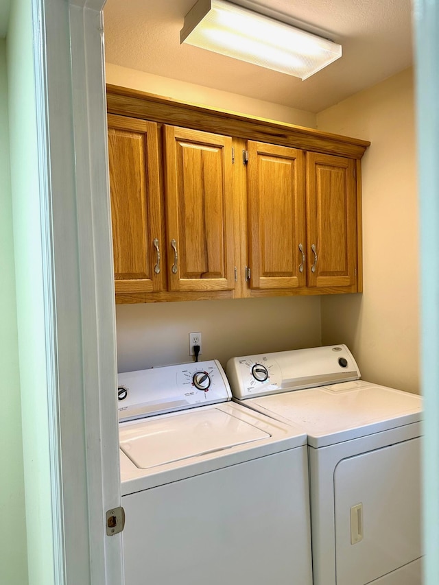 washroom with cabinets and washer and clothes dryer