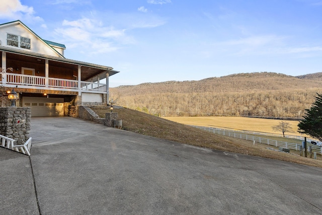 view of yard featuring a balcony, a garage, and a mountain view