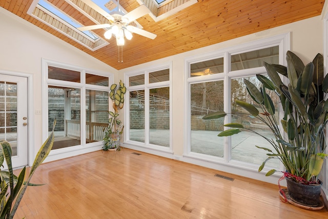 unfurnished sunroom with wood ceiling, lofted ceiling with skylight, and ceiling fan