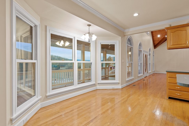 unfurnished dining area featuring crown molding, a chandelier, and light wood-type flooring