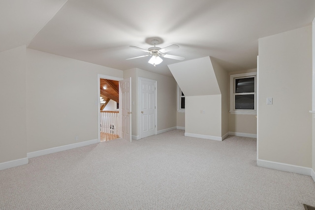 additional living space with lofted ceiling, light carpet, and ceiling fan