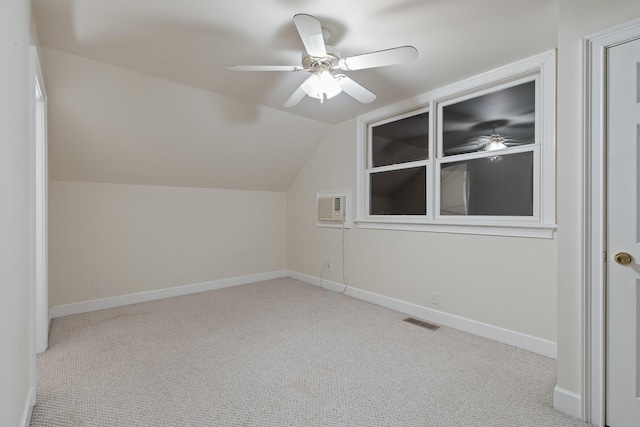 additional living space featuring light carpet, vaulted ceiling, a wall unit AC, and ceiling fan