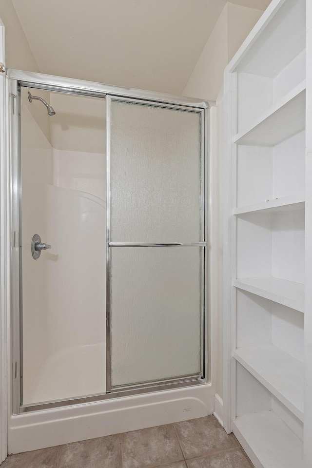 bathroom with walk in shower and tile patterned flooring