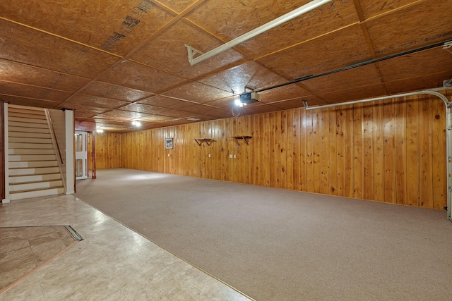 basement featuring carpet and wood walls