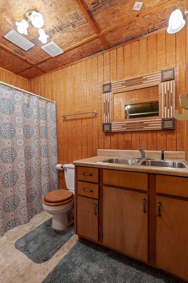 bathroom featuring vanity, wooden walls, and toilet