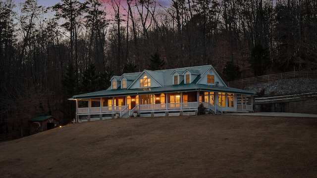 farmhouse with a porch and a lawn