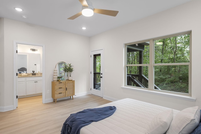 bedroom with access to exterior, ensuite bath, light hardwood / wood-style floors, and sink