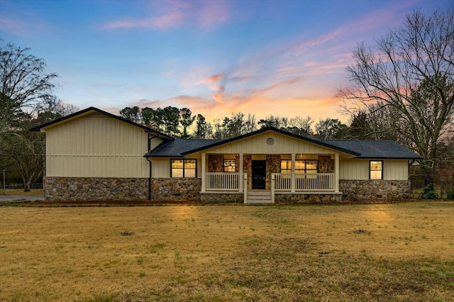 single story home with covered porch and a lawn