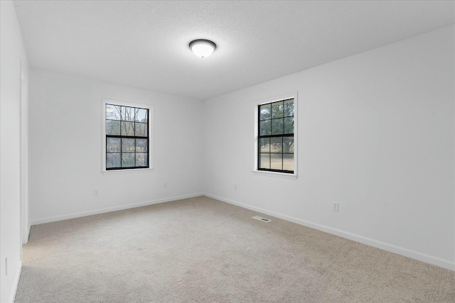 carpeted empty room with a textured ceiling